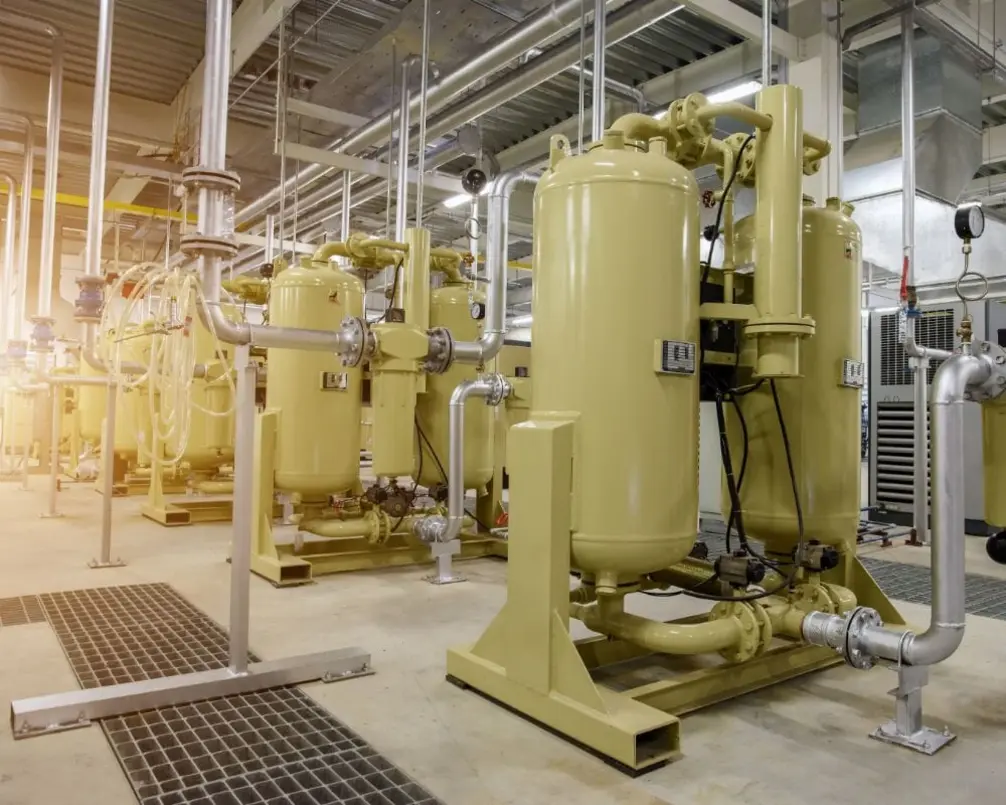 Compressed-air equipment in a food production facility, featuring multiple yellow tanks and piping.