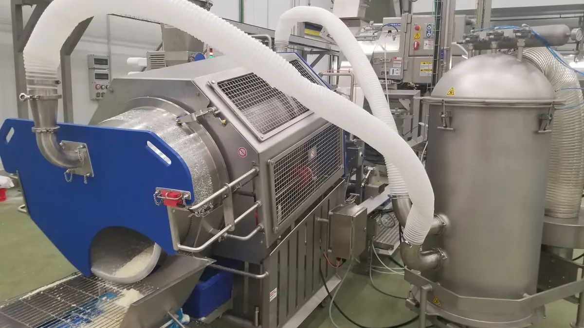 Dust collection system with a large machine and connected tubing in a food processing facility.