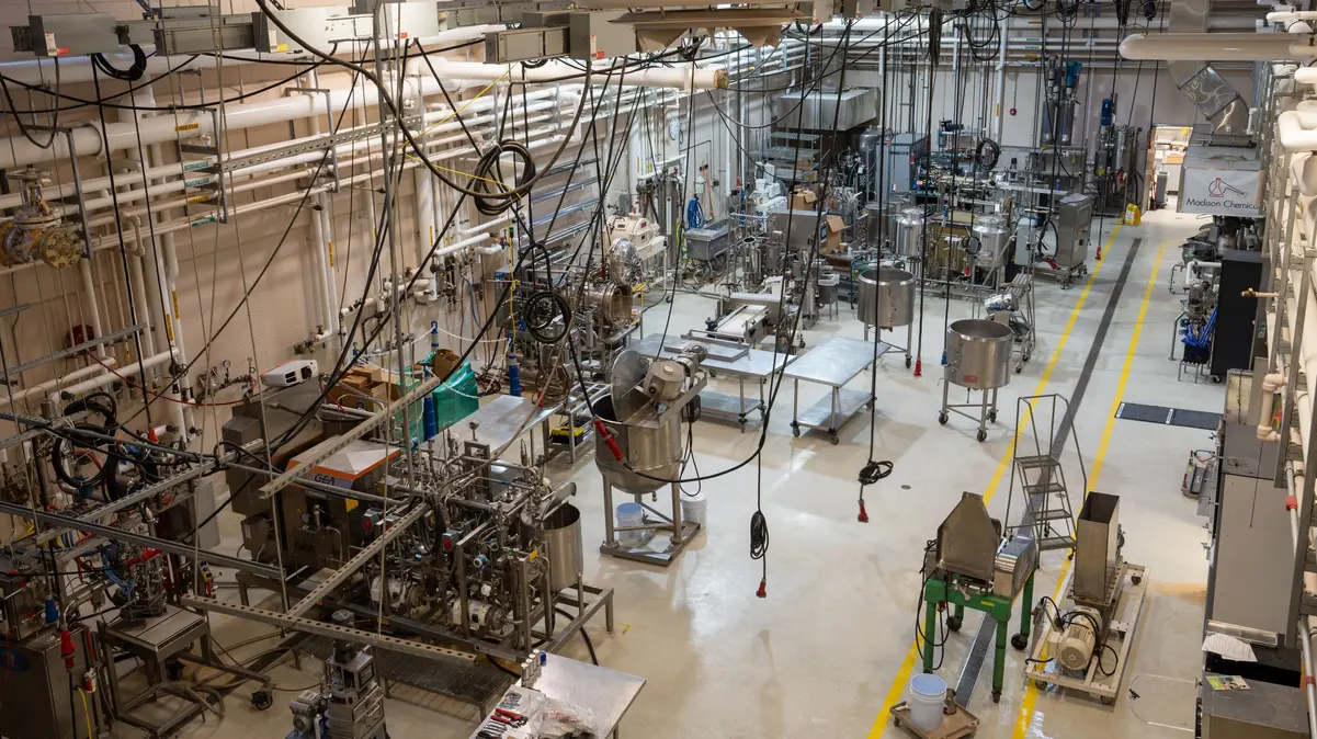 A pilot-scale food production facility with various interconnected processing equipment and overhead piping.