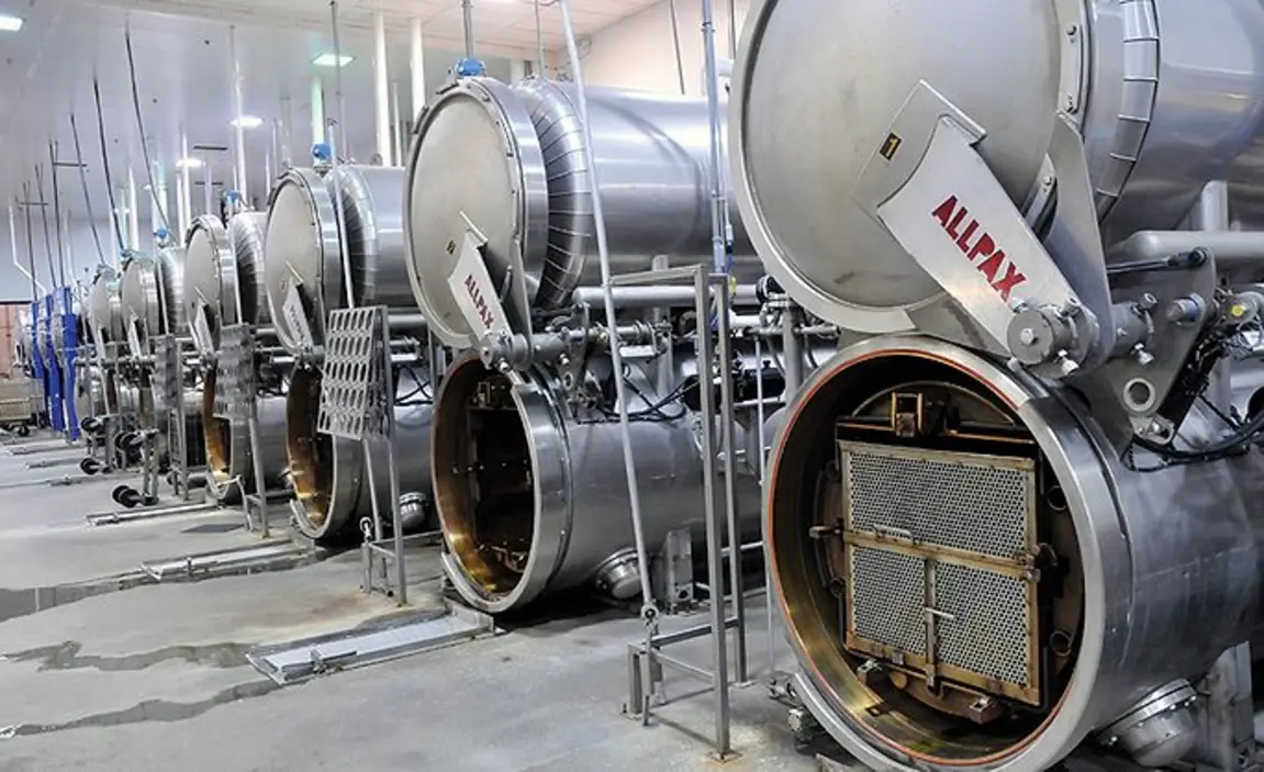 Horizontal industrial food retorts lined up in a processing facility.