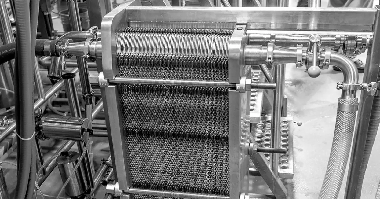Sanitary heat exchanger with metal plates and tubing for food processing applications.